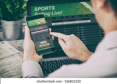 betting bet sport phone gamble laptop over shoulder soccer live home website concept - stock image - Powered by Shutterstock