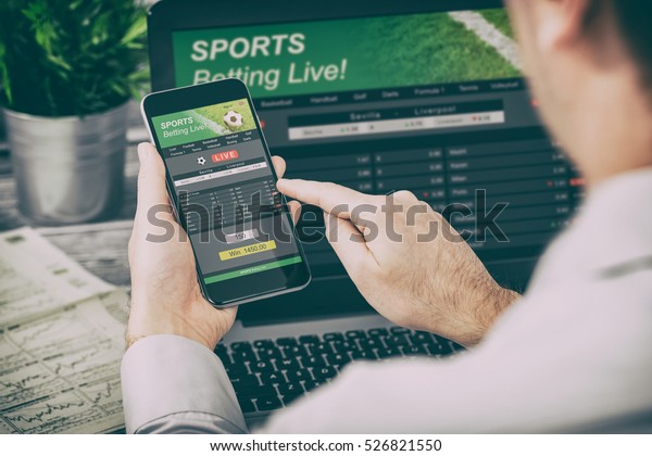 betting bet sport phone\
gamble laptop over shoulder soccer live home website concept -\
stock image