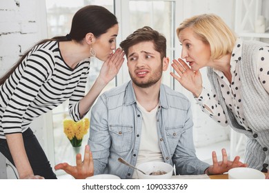 Between two fires. Cheerless young man not knowing what to do while being between two fires