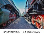 between wagons of old trains, between two old trains, red metal train wheels