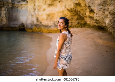 Beutiful latin mexican girl tourist walking  on beach with rocks on beautiful beach near ocean 