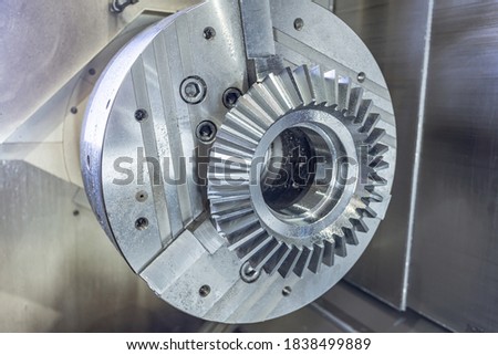 Bevel gear in a chuck on a cnc machine, machining center in production.