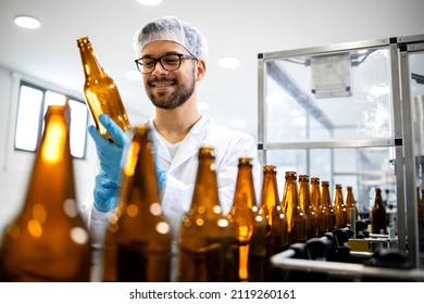 Beverage bottling factory and technologist worker checking beer bottles before filling with alcohol drink. - Powered by Shutterstock