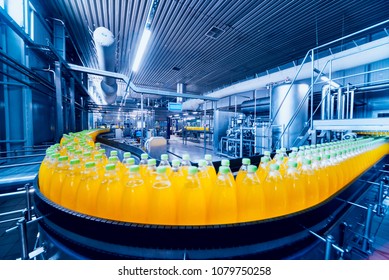 Beverage factory interior. Conveyor with bottles for juice or water. Modern equipments - Shutterstock ID 1079750258