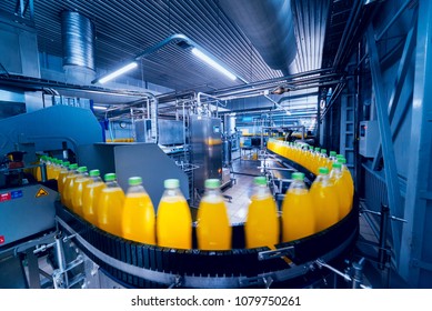 Beverage factory interior. Conveyor with bottles for juice or water. Modern equipments - Shutterstock ID 1079750261