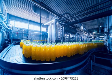 Beverage factory interior. Conveyor with bottles for juice or water. Modern equipments - Shutterstock ID 1099475261