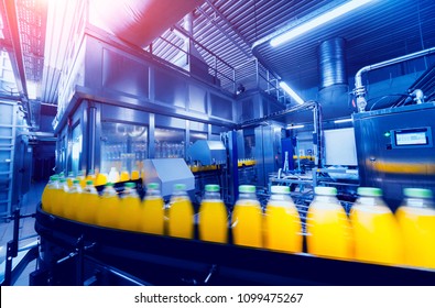 Beverage factory interior. Conveyor with bottles for juice or water. Modern equipments - Shutterstock ID 1099475267