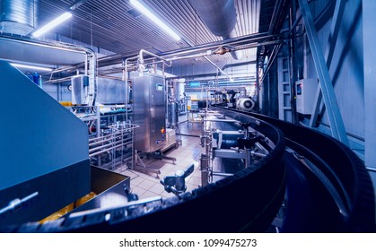 Beverage factory interior. Conveyor with bottles for juice or water. Modern equipments - Shutterstock ID 1099475273