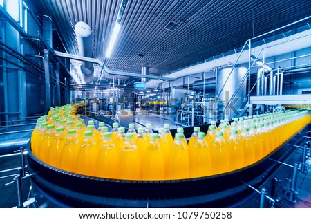Beverage factory interior. Conveyor with bottles for juice or water. Modern equipments