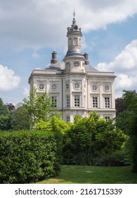 Beveren, Belgium, May 22, 2022, Hof Ter Saksen Castle, With Blue Sky And A Field Of Clouds And In The Foreground The Garden With Tall Plants