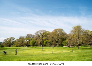 BEVERLEY, UK - APRIL 15, 2022: Westwood public parkland and golf coursese with players flanked by woodland trees on the Westwood on fine spring morning on April 15, 2022 in Beverley, Yorkshire, UK.