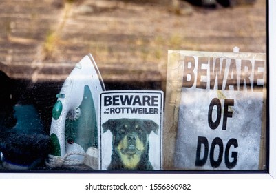 Beware Of The Dog Warning Signs In Window Of House.