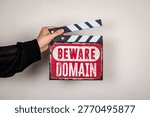 Beware Domain text on warning sign with clapperboard representing cybersecurity concept