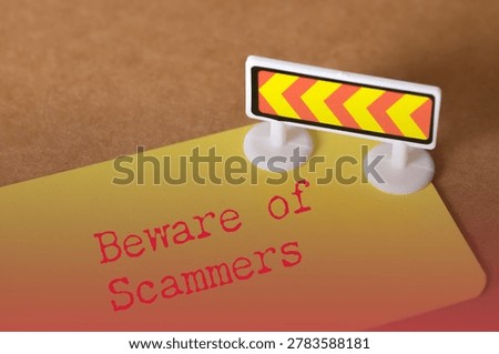 Beware of Scammers warning message on yellow card with barricade sign