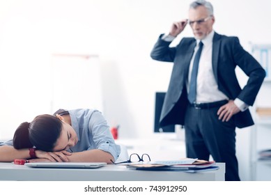 Bewildered Chief Looking At His Employee Sleeping At Work