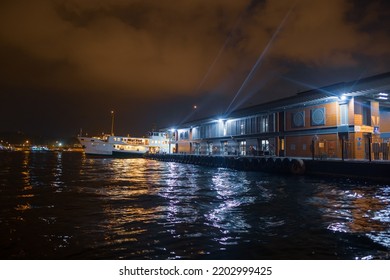 Beyoglu, Istanbul, Turkey - 07.07.2021: Shiny Bright Night Lights Of Karakoy Pier And Istanbul Passenger Ship Parked At Night Time And Waiting For People Before Moving For Transportation Travel Trip