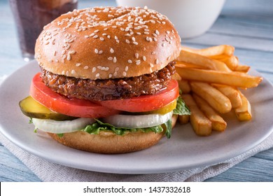 A Beyond Delicious Plant Based Non Meat Burger With Lettuce, Onion, Pickle, Tomato And French Fries.