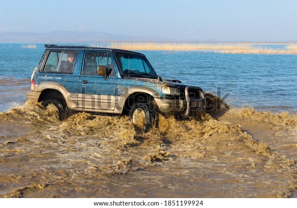 Beysehir, Konya / Turkey - 05.05.2020:\
Offroad car on water. Off-road jeep expedition. Mud and water\
splash in off-road racing. Off-road car on the\
sea.