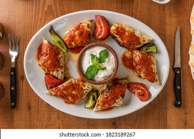 Beyti Kebab served with yoghurt on  the wooden table - Shutterstock ID 1823189267