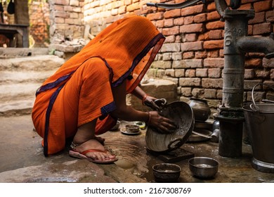 Bhabua, Bihar, India - March 05, 2022: A Bihar woman washing utensils by the roadside