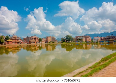 BHAKTAPUR, NEPAL - NOVEMBER 04, 2017: Close up of blurred traditional urban scene with an artificial pond of yellow water at Bhaktapur city, Nepal