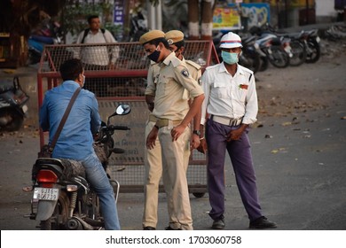 Bharuch, Gujarat / India - April 05 2020: Covid 19 Corona Virus 21 days lockdown in India. Indian police man on duty to stop people from roaming in city. Selective focus on man and background blur.