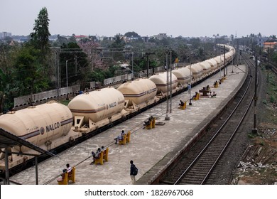 Bhubaneswar, India - February 4, 2020: A Freight Train Pass Through The City As People Wait On Benches At The Station On February 4, 2020 In Bhubaneswar, India