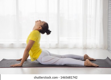 Bhujangasana pose (cobra pose) .Asian middle-aged women wear sports clothing doing Cobra exercise. White translucent curtain background - Shutterstock ID 1465681742