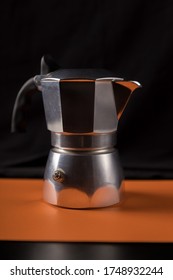 Bialetti geyser coffee maker, silver Brikka on black and yellow background, low key
