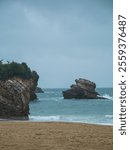 Biarritz coastline with beach, blue sea, and overcast rainy weather