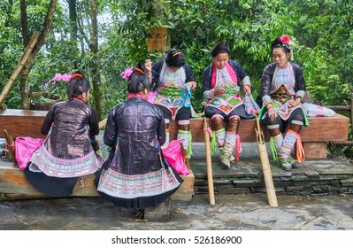 Biasha, China - May 2, 2016: a group of Miao minority girls get together sewing at open air in the chinese village Biasha, Province of Guizhou, China