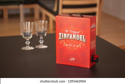 BIB Bag In Box With Italian Zinfandel Puglia Red Wine With Two Glasses In The Background. Copenhagen, Denmark - April 28, 2019.