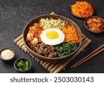 Bibimbap is a Korean dish in the form of a bowl of white rice topped with side dishes of vegetables, beef, eggs and spicy gochujang sauce.