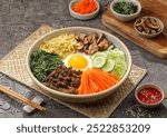 Bibimbap is a Korean dish in the form of a bowl of white rice topped with side dishes of vegetables, beef and spicy gochujang sauce.