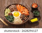 Bibimbap is a Korean dish in the form of a bowl of white rice topped with side dishes of vegetables, beef, eggs and spicy gochujang sauce.