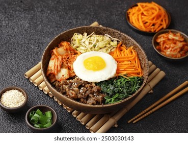 Bibimbap is a Korean dish in the form of a bowl of white rice topped with side dishes of vegetables, beef, eggs and spicy gochujang sauce. - Powered by Shutterstock