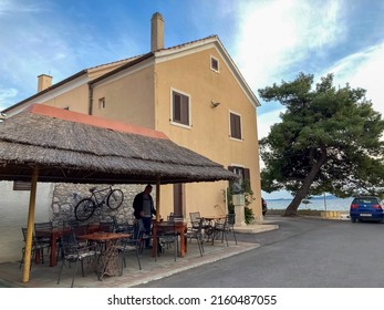 Bibinje, Zadar, Croatia-May, 4, 2022: View Of The Yellow Building And Cafe Under The Roof. Selective Focus 