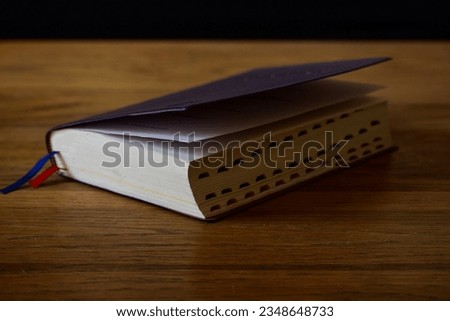 a bible with a blue cover on top of a wooden table