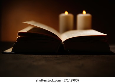 Bible And Burning Candles On Table