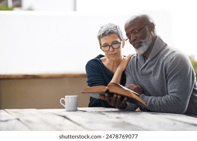 Bible, coffee and faith with elderly couple outdoor in garden together for reading or religion. Belief, Christian or God with serious senior man and woman in park for learning to trust in Jesus - Powered by Shutterstock