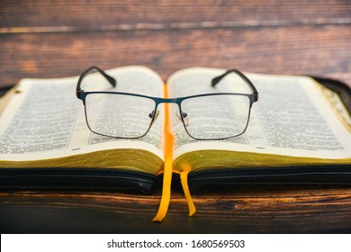 The Bible And Glasses, Glasses For Sight Lie On The Opened Bible Of A Gift Issue With Gilded Pages.