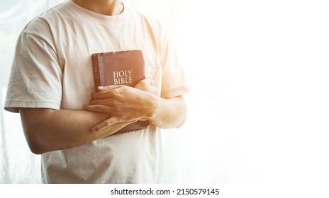 The Bible is in hand, praying by hand and praying together. with religious faith and belief in god on blessing background The power of hope or love and devotion. - Shutterstock ID 2150579145