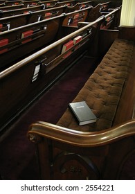 Bible On Empty Pew. Focused On Bible. Empty Church With Lots Of Pews.