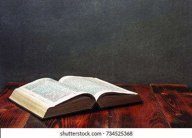 Bible On A Wooden Brown Table. Beautiful Blue Background.Religion Concept.