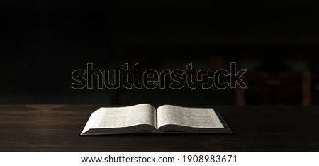 Bible. Open book Bible Scripture. Bible Holy. On a wooden table. In the dark