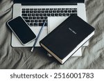 Bible, phone, laptop and cup of coffee on a grey bed background. Christian online technology concept. Online live church for Sunday service. Holy Bible book and online study.