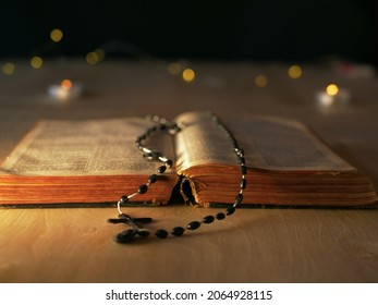 Bible And Rosary Beads In Candlelight Bokeh Light Background Medium Shot