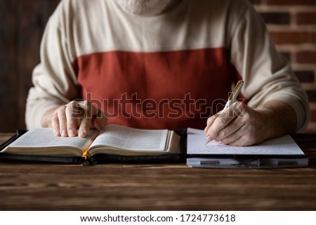 Bible study following the word of Scripture and copying it on paper. Taking notes and study of the Holy Bible. Searching for a spiritual subject