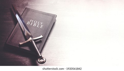 Bible and a Sword on a Dark Wooden Table