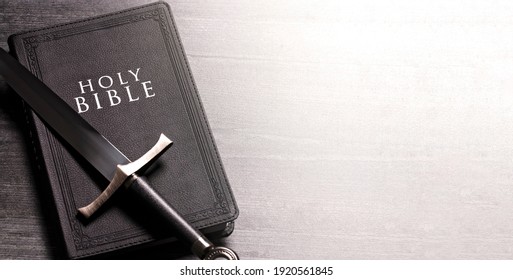 Bible and a Sword on a Dark Wooden Table - Shutterstock ID 1920561845